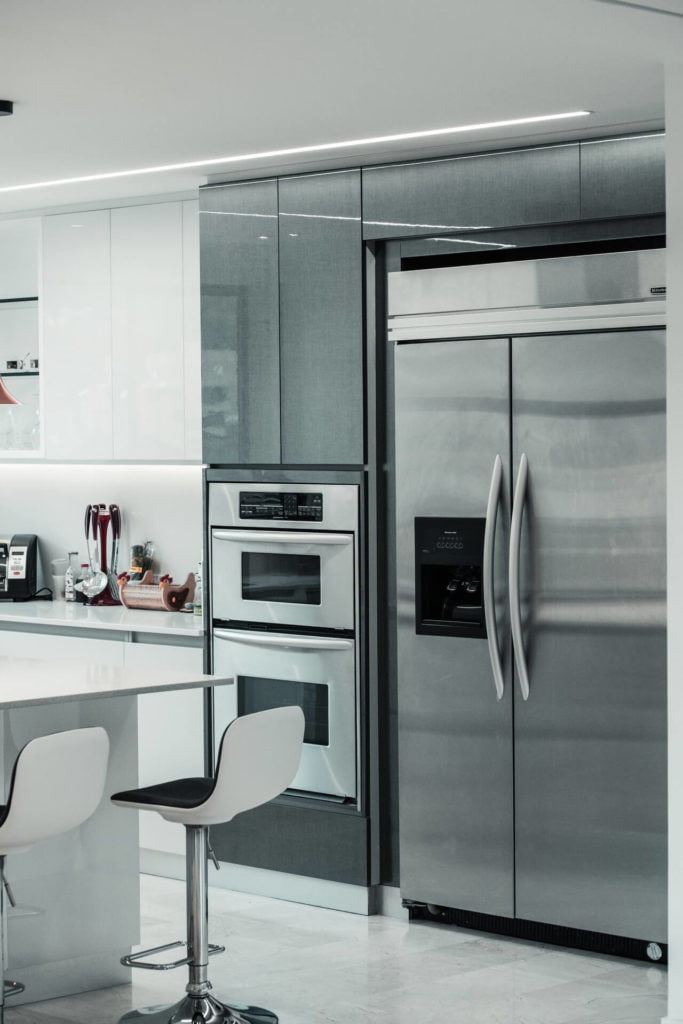 a kitchen with a refrigerator and chairs