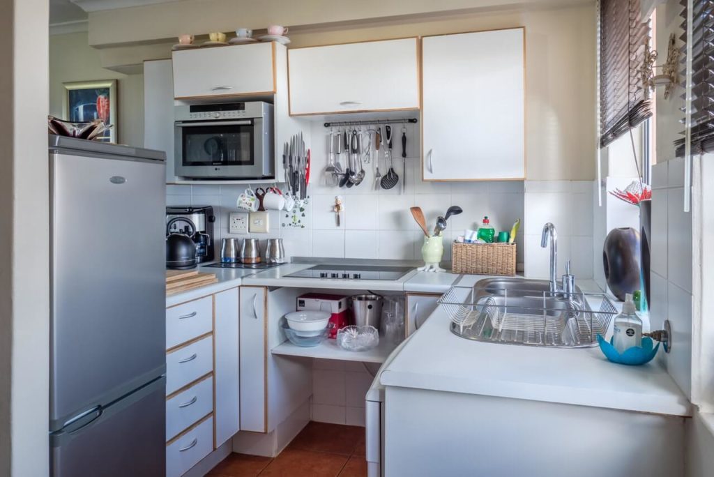 a small kitchen with white cabinets