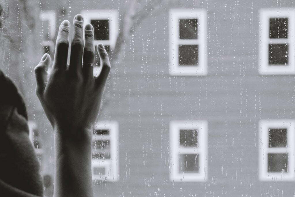 a person's hand holding a camera in front of a house