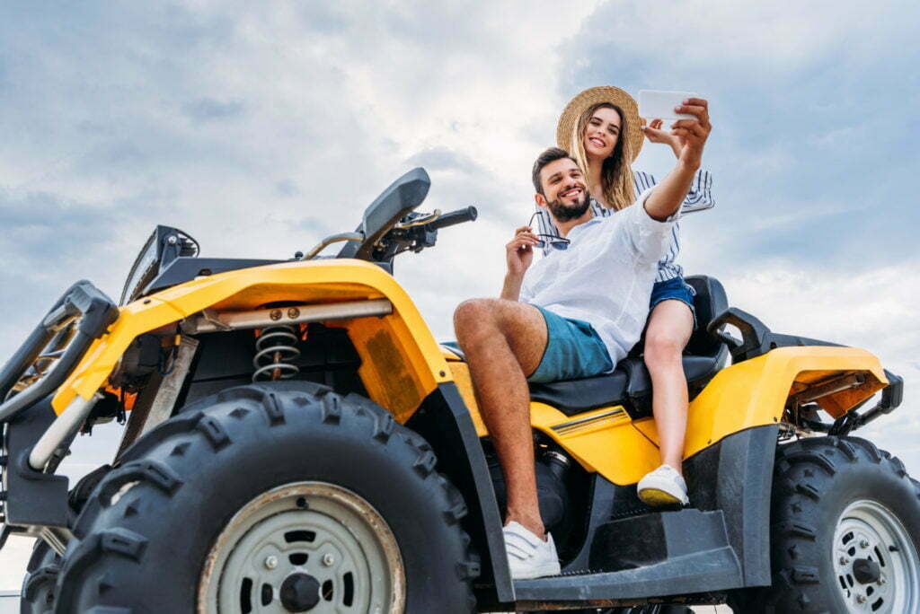 a man and woman riding a yellow tractor