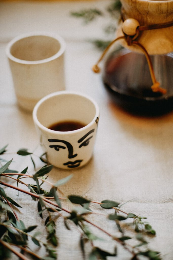 a cup of coffee and a mug on a table