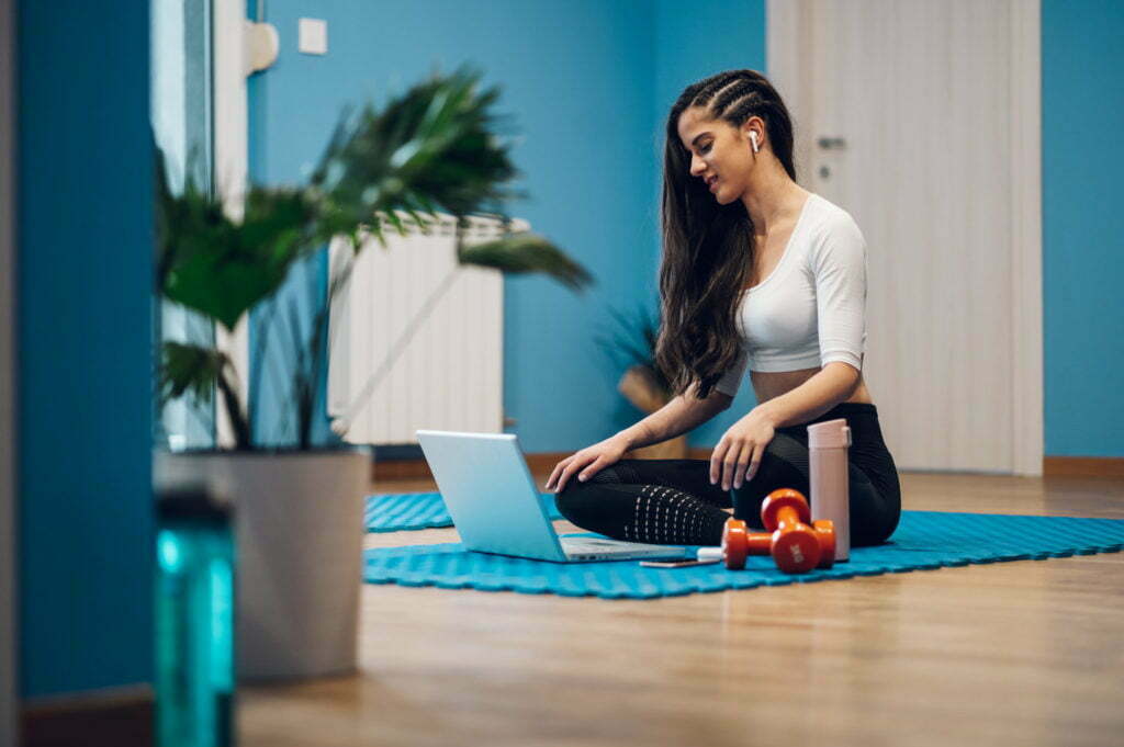 Woman training at home and coaching an online fitness routine