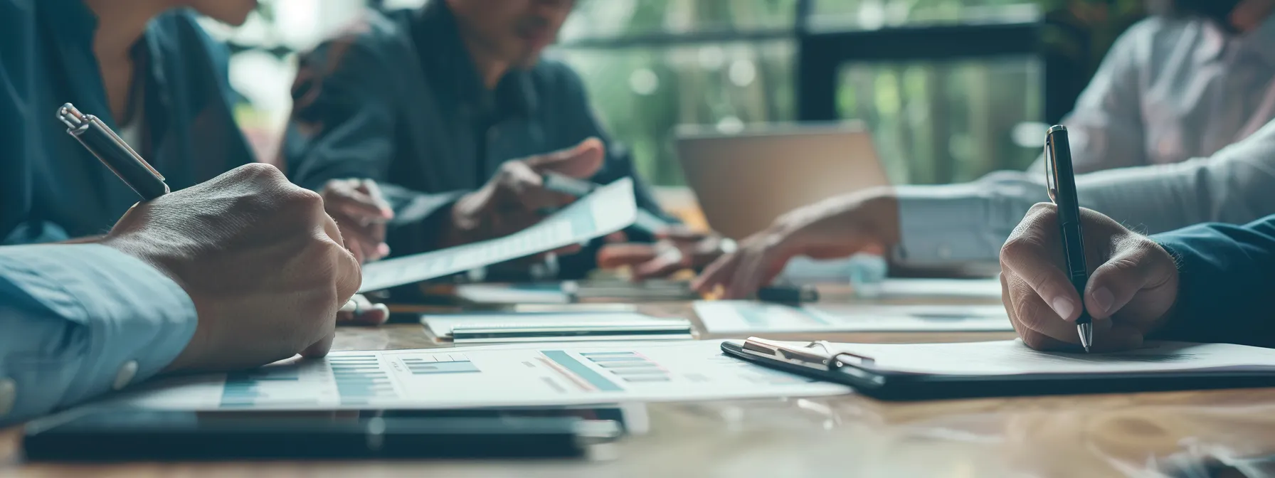 a group of professionals around a table, pointing to a chart showing cost structures and discussing service agreements.